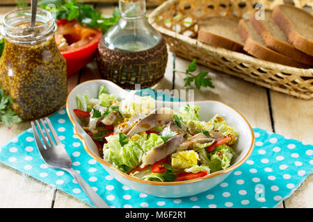 Easter recipe, festive snack. Salad with Pekinese cabbage, herring, sweet pepper and onions - on the festive table. Stock Photo