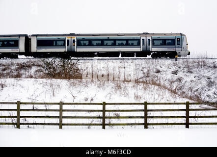 A Chiltern Railways class 168 train, side view, snowy in winter, Warwickshire, UK Stock Photo