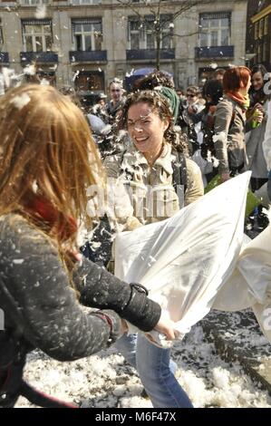 Two young women having fun on Pillow Fight Day, an international public outdoor event held every year in different cities Stock Photo