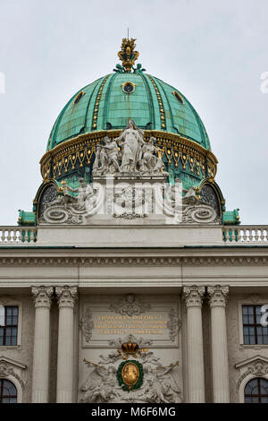Ornate domed roof and statues above the entrance to the Imperial Hofburg Palace St Michael's Wing Vienna Stock Photo