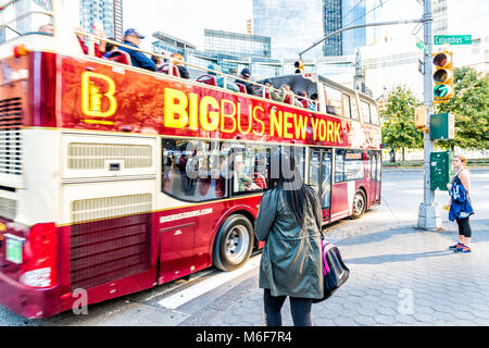 New York City, USA - October 28, 2017: Manhattan NYC midtown Columbus Circle, Broadway street road, Big bus bigbus, young woman walking by red double  Stock Photo