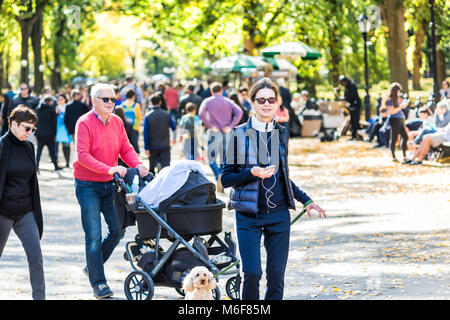 New York City, USA - October 28, 2017: Manhattan NYC Central park with people walking on street alley, in autumn fall season, baby stroller Stock Photo