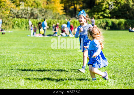 New York City, USA - October 28, 2017: Manhattan NYC Central park Great Lawn in with young children girls toddlers running playing having fun on green Stock Photo