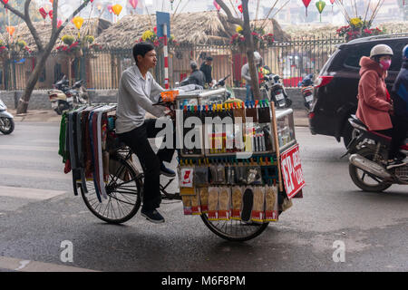 A man rides his bicycle which has been adapted into a mobile shop selling toiletries in Hanoi, Vietnam Stock Photo