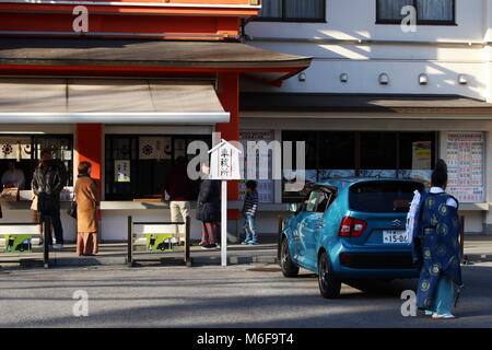 View of the front of a Chiba Shrine in Chiba City where a priest is performing a Shinto exorcism ritual on a car. (February 2018) Stock Photo