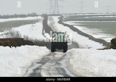 Compton Valence, Dorset, UK.  3rd March 2018.  UK Weather.  A tractor driving along the Roman Roan near Compton Valence in Dorset, flanked by large snow drifts from Storm Emma.  The snow is begining to thaw with most of the fields almost snow free but the drifts along the roads remain and in places are 4-5 feet high.  Picture Credit: Graham Hunt/Alamy Live News Credit: Graham Hunt/Alamy Live News Stock Photo