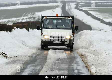 Compton Valence, Dorset, UK.  3rd March 2018.  UK Weather.  A van driving along the Roman Roan near Compton Valence in Dorset, flanked by large snow drifts from Storm Emma.  The snow is begining to thaw with most of the fields almost snow free but the drifts along the roads remain and in places are 4-5 feet high.  Picture Credit: Graham Hunt/Alamy Live News Credit: Graham Hunt/Alamy Live News Stock Photo