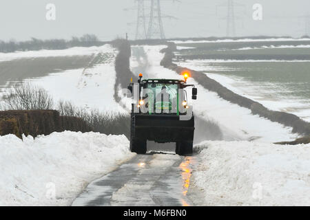 Compton Valence, Dorset, UK.  3rd March 2018.  UK Weather.  A tractor driving along the Roman Roan near Compton Valence in Dorset, flanked by large snow drifts from Storm Emma.  The snow is begining to thaw with most of the fields almost snow free but the drifts along the roads remain and in places are 4-5 feet high.  Picture Credit: Graham Hunt/Alamy Live News Credit: Graham Hunt/Alamy Live News Stock Photo
