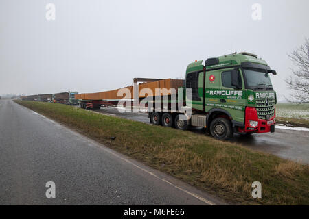 Heavy haulage trucks carrying metal for bridge construction for the 2018 Ely Bypass. Parked in layby awaiting for delivery. Largest load 150 Tonns (load and truck), 45m long. Ironwork carried from southern Wales to Ely. Stock Photo