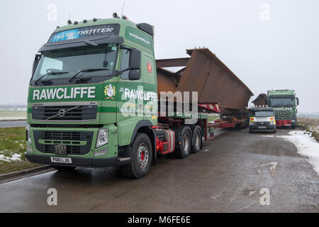 Heavy haulage trucks carrying metal for bridge construction for the 2018 Ely Bypass. Parked in layby awaiting for delivery. Largest load 150 Tonns (load and truck), 45m long. Ironwork carried from southern Wales to Ely. Stock Photo