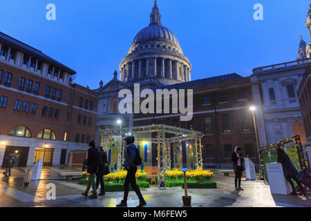 Paternoster Square, City of London, 3rd March 2018. The installation is illuminated in the evening, with St Paul's Cathedral in the background. Spring has sprung, at least in Paternoster Square, where 4,000 handmade daffodils have appeared as part of the 'Garden of Light' installation, created by the terminal illness care charity Marie Curie. Part of the Great Daffodil Appeal, members of the public can also leave messages on a wall. The daffodils are illuminate in the evening and will remain in the square from Sat 3rd to Sun 11th March. Credit: Imageplotter News and Sports/Alamy Live News Stock Photo