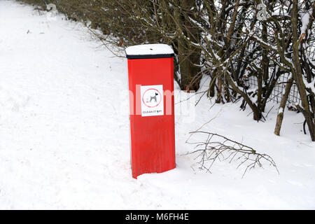 A dog poo bin on a snowy day in Peterborough, Cambridgeshire. Snow, Peterborough, on March 3, 2018. Stock Photo