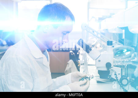 Computer expert professional technician examining board computer in a laboratory in a factory. The concept of high computer technologies and innovations. Conceptual. Stock Photo