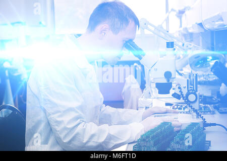 Computer expert professional technician examining board computer in a laboratory in a factory. The concept of high computer technologies and innovations. Conceptual. Stock Photo