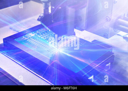 The concept of future technologies. Computer board with visual effects in a futuristic style. Automation of machine assembly of computer circuit board. The process of soldering the board. Stock Photo
