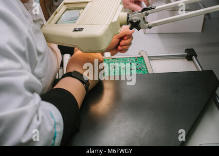 Female computer expert professional technician examining board computer in a laboratory in a factory. Stock Photo