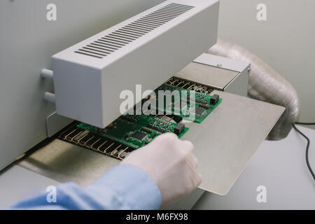 Computer expert professional technician examining board computer in a laboratory in a factory. Technical support. Stock Photo