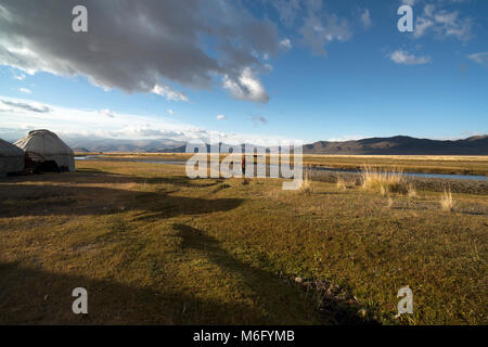 A nomadic Kazakh woman walks to a stream to fetch drinking water. Altai Mountains, Mongolia. Stock Photo