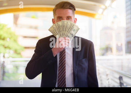 Portrait of Businessman holding Money Cash Dollars in hands. Concept of finance success.