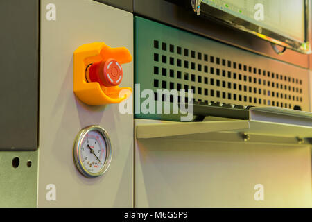 Emergency stop button and vacuum gage in machine Stock Photo