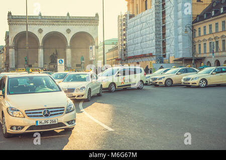 Munich, Germany, December 29, 2016: Many traditional Bavarian taxis at the Odeonsplatz square in the center of Munich. Transportation of passengers. Everyday life in Munich. Heavy traffic. Stock Photo