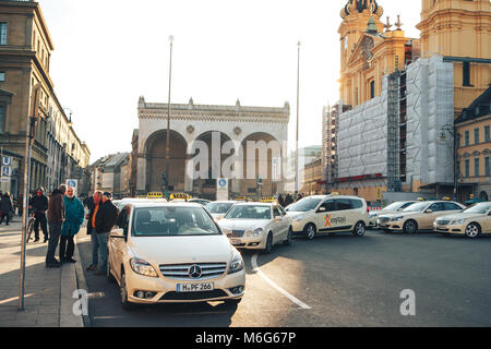 Munich, Germany, December 29, 2016: Many traditional Bavarian taxis at the Odeonsplatz square in the center of Munich. Transportation of passengers. Everyday life in Munich. Heavy traffic. Stock Photo