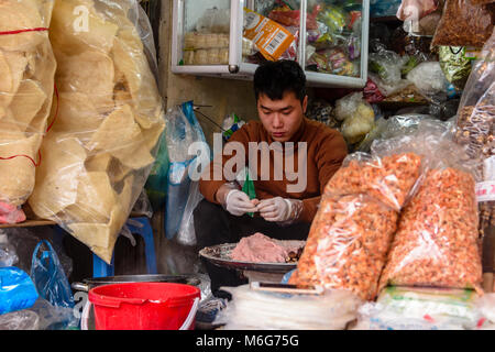 A man prepares street food at his shop in Hanoi, Vietnam Stock Photo