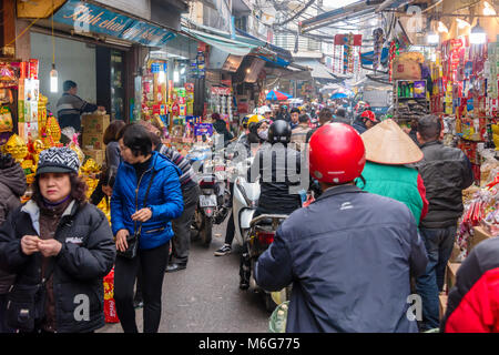 Scooters and pedestrians contest for room in a narrow street in Hanoi, Vietnam Stock Photo