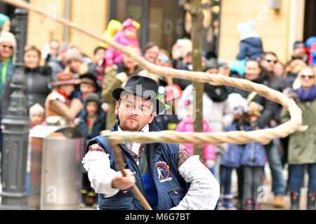 Ljubljana, Slovenia - February 10, 2018 - Traditional carnival on shrove Saturday and person with big rope-made whip, which creates loud bang, Ljublja Stock Photo