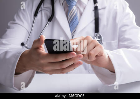 Close-up Of A Doctor's Hand Using Smartphone In Clinic Stock Photo