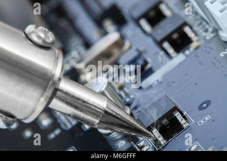 Soldering iron and microcircuit next to it - close up studio shot Stock Photo