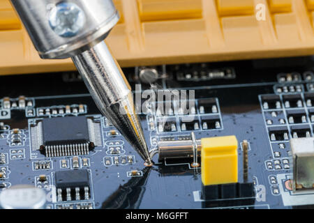 Soldering iron fixing microcircuit - close up studio shot Stock Photo