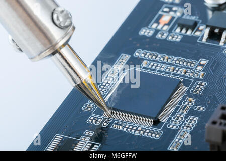 Fixing microcircuit with soldering iron - close up studio shot Stock Photo
