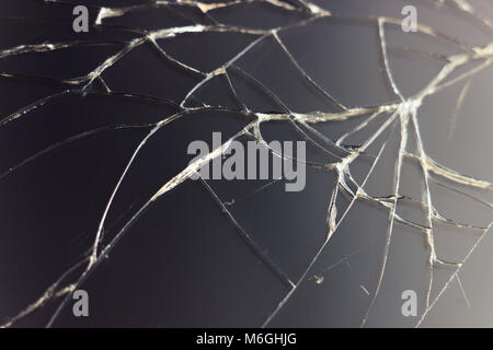 Close-up macro of broken dark glass. Abstract black background with white lines. Elements of smartphone (screen). Stock Photo