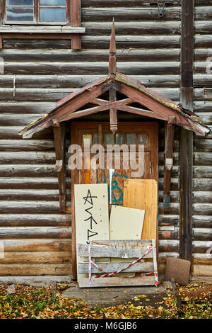 An abandoned two-storey log house in the city after the relocation of residents Stock Photo