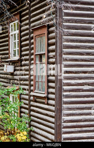 An abandoned two-storey log house in the city after the relocation of residents Stock Photo