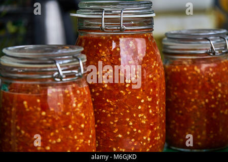 Canning the hot pepper. Glass jars with hot pepper. Grinded hot cayenne pepper in glass jars Stock Photo