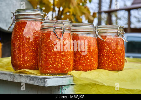 Canning the hot pepper. Glass jars with hot pepper. Grinded hot cayenne pepper in glass jars Stock Photo