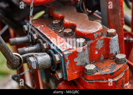 Big bright red homemade power tractor using details and wires from other tractors. Engine with unclosed tubes and wires close-up Stock Photo