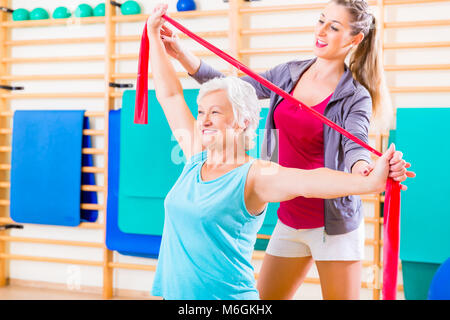 Senior woman with stretch band at fitness Stock Photo
