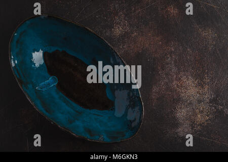 Beautiful empty blue plate on a dark rusty background. Copy space, top view. Stock Photo