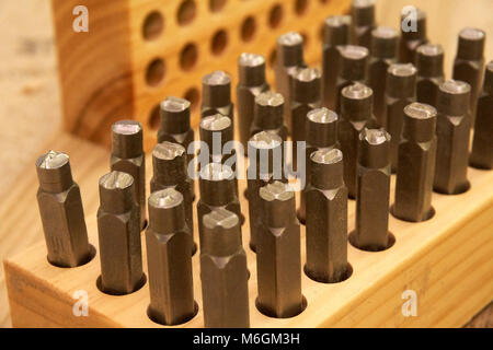 An organized assortment of metal letter stamps neatly nestled in their wooden storage case closeup view Stock Photo