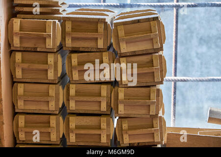 Wooden military style souvenir or gift boxes placed on workbench in workshop Stock Photo