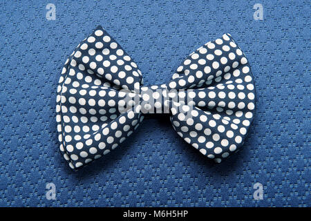 High angle view of spotted bow-tie against blue textile background Stock Photo