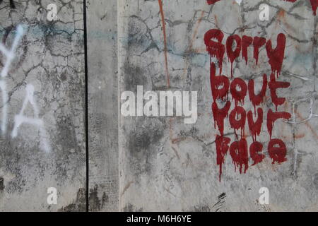 Sorry about your face - Graffiti on a cracked concrete Wall at Kuta Beach, Bali, Indonesia. Stock Photo