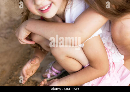 Two Happy little girls laughing and embracing at the  summer park Stock Photo