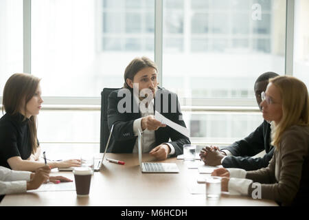 Angry boss reprimanding employee for bad work result at meeting Stock Photo