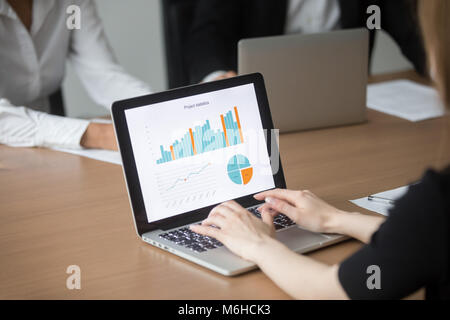 Female manager working on laptop at meeting analyzing project st Stock Photo