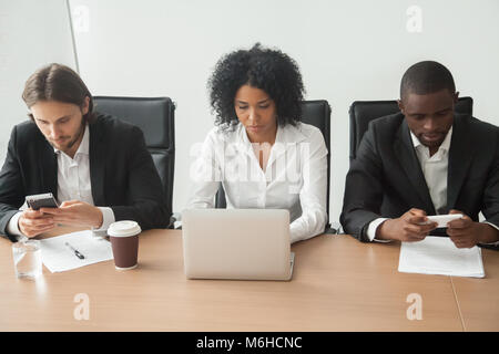 Multiracial business people sitting at office table using corpor Stock Photo