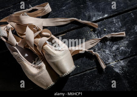 Pointe shoes on wooden background on theater stage Stock Photo